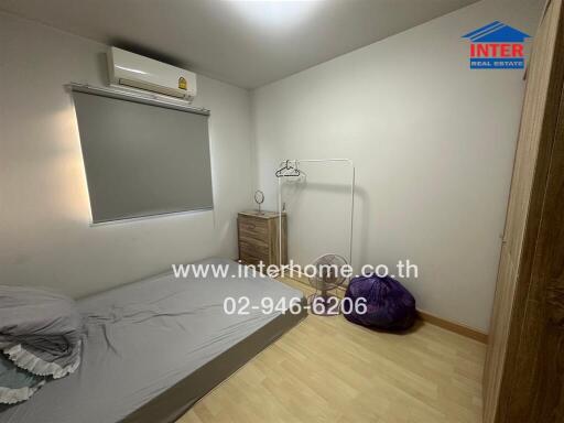 Bedroom with a single bed, air conditioning, and wooden floor