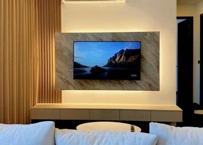 Modern living room with wall-mounted TV and comfortable sofa