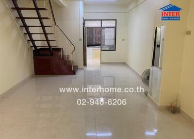 Spacious living room with staircase and large window