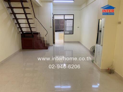 Spacious living room with staircase and large window