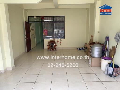 Living room with white tile flooring and some storage items