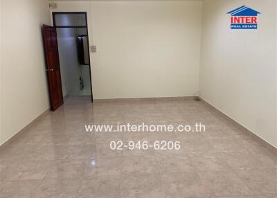 Empty living room with tiled floor and door to another room