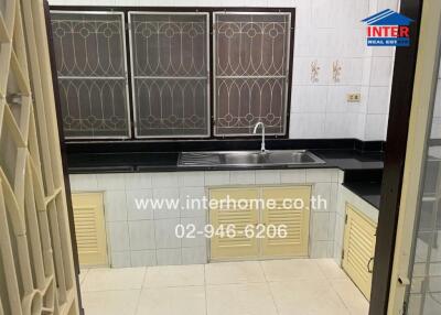 Kitchen with stainless steel sink and ventilation windows