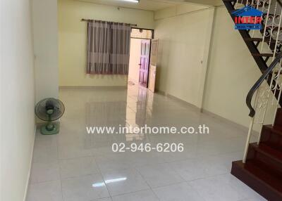 Spacious living room with tiled floor and staircase