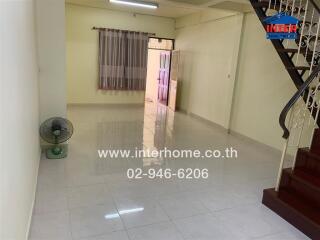 Spacious living room with tiled floor and staircase