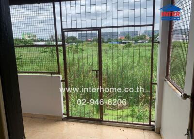 Balcony with metal grill and view of greenery