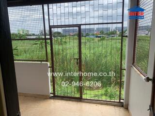 Balcony with metal grill and view of greenery