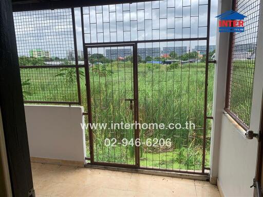 Balcony with metal grill and view of greenery