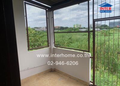 View of the balcony with wire mesh and surrounding greenery