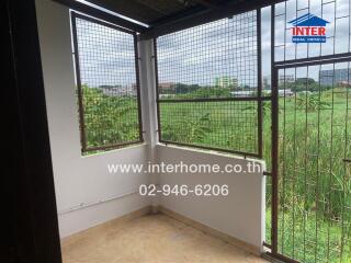 View of the balcony with wire mesh and surrounding greenery