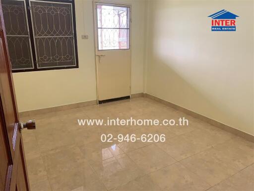 Empty room with tiled floor and a door leading outside