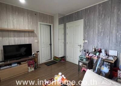 Living room with wood panel walls, a TV on a stand, and a coffee table