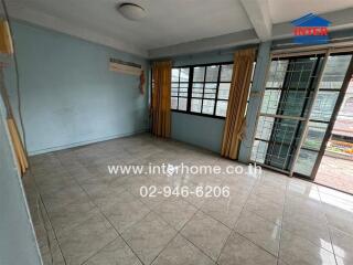 Spacious living room with tiled flooring and large windows