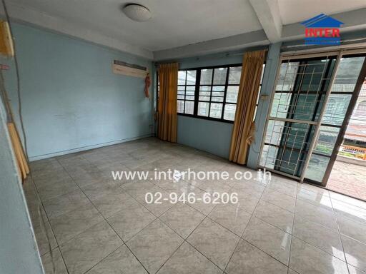 Spacious living room with tiled flooring and large windows