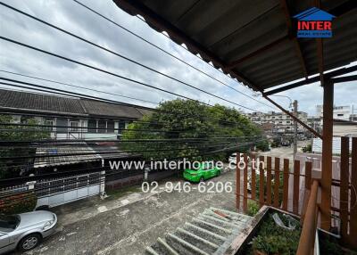 View of balcony overlooking street and neighboring houses