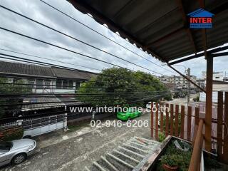 View of balcony overlooking street and neighboring houses