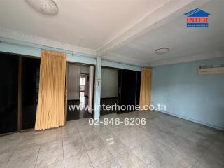 Spacious living room with tiled flooring and large windows