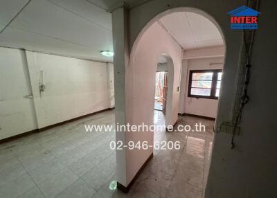 Empty living space with an arched doorway