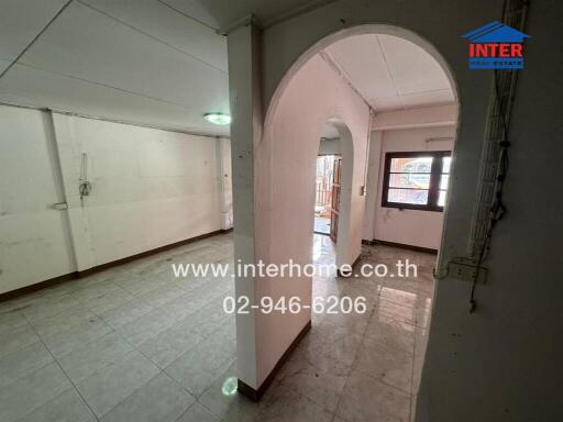 Empty living space with an arched doorway