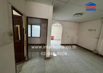 Interior view of a residential space with tiled floors and visible archway.