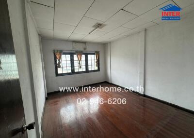 Unfurnished bedroom with wooden floors and large windows