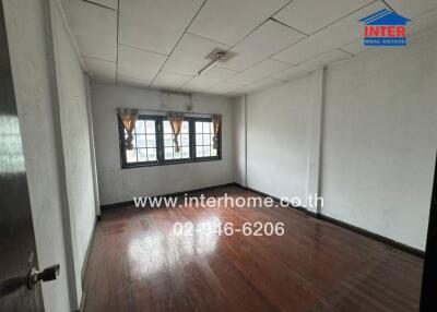 Bedroom with wooden flooring and curtains on windows