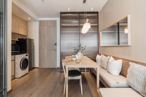 Modern dining area with built-in seating and adjacent laundry appliances