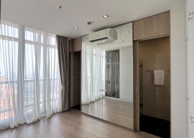 Modern bedroom with large windows, hardwood flooring, and a built-in wardrobe