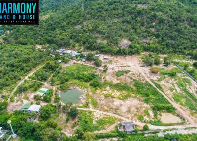 Aerial view of a property area with greenery, ponds, and multiple structures