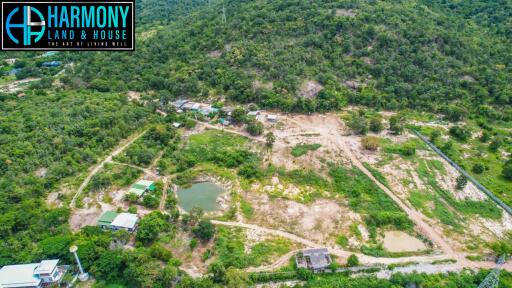 Aerial view of a property area with greenery, ponds, and multiple structures