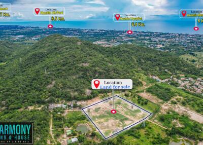 Aerial view of land for sale with multiple location markers indicating distances to nearby places