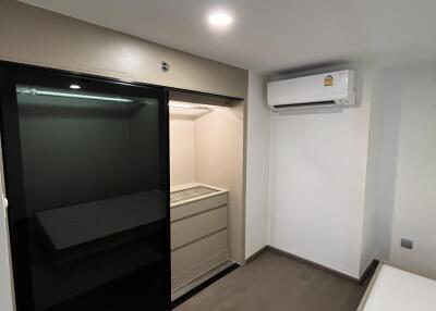 Minimalist bedroom with built-in closet and air conditioner