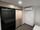 Minimalist bedroom with built-in closet and air conditioner