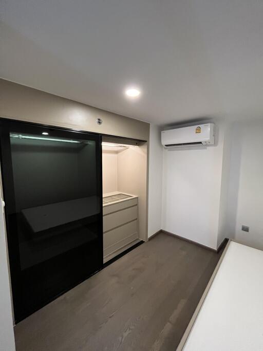 Minimalist bedroom with built-in closet and air conditioner