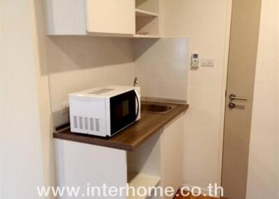 Compact kitchen with microwave and storage cabinets