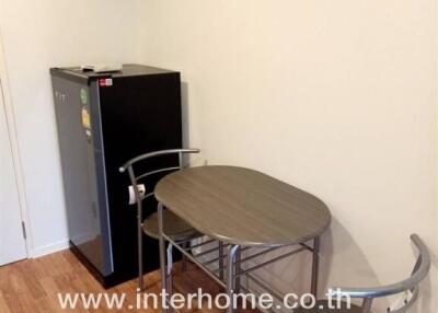 Small dining area with table, chairs, and mini refrigerator in a kitchen