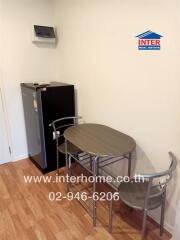 Small dining area with table, chairs, and mini refrigerator in a kitchen