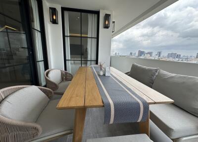 Modern balcony with a table, chairs, and city view