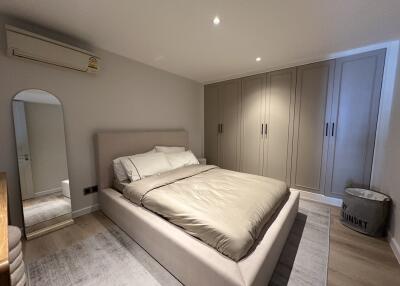 Modern bedroom with built-in wardrobes and mirror