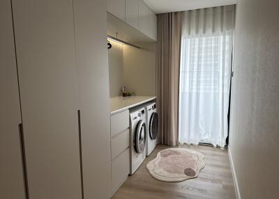 Modern laundry room with washer and dryer units and ample storage