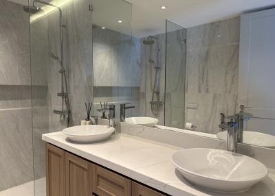 Modern bathroom with double sinks and glass shower