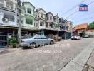 Street view of multi-story residential buildings with cars parked in front