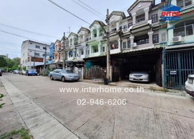 Street view of residential buildings with cars parked outside