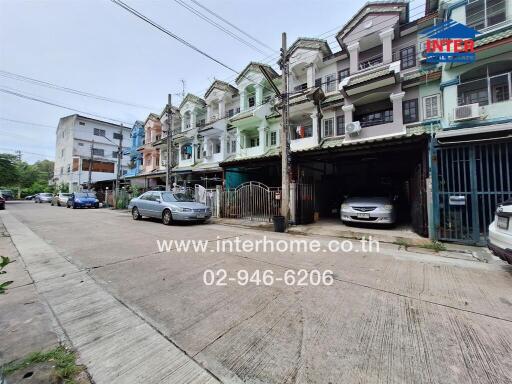 Street view of residential buildings with cars parked outside