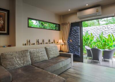 Comfortable living room with garden view through large glass doors