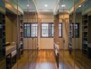 Spacious walk-in closet with mirrored doors and hardwood floors