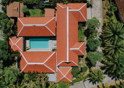 Aerial view of a property with red-roofed buildings and a swimming pool