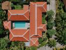 Aerial view of a property with red-roofed buildings and a swimming pool