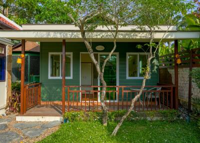 Exterior view of a green house with a porch