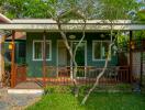 Exterior view of a green house with a porch